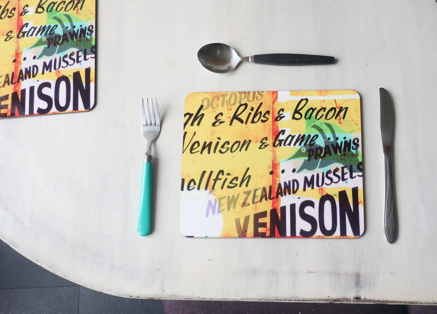 Colorful placemat with text on a table with cutlery
