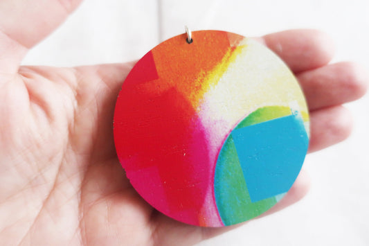 Colorful circular object held in a hand with a white background