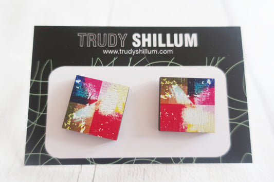 Colorful square earrings on a white stand with 'Trudy Shillum' branding in the background.