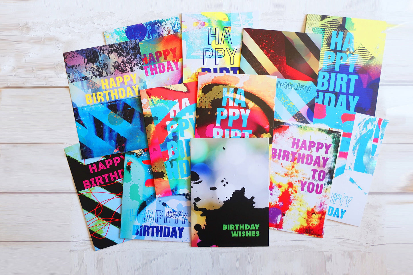 Collection of colorful birthday cards on a light wooden surface