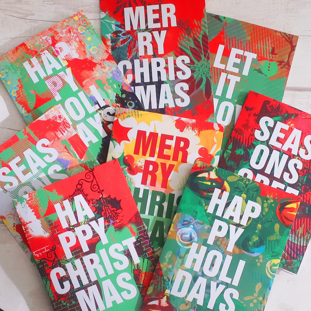 Colorful Christmas-themed greeting cards on a light wooden surface
