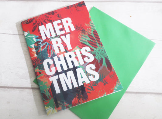 Colorful Christmas card with 'Merry Christmas' text on a white surface