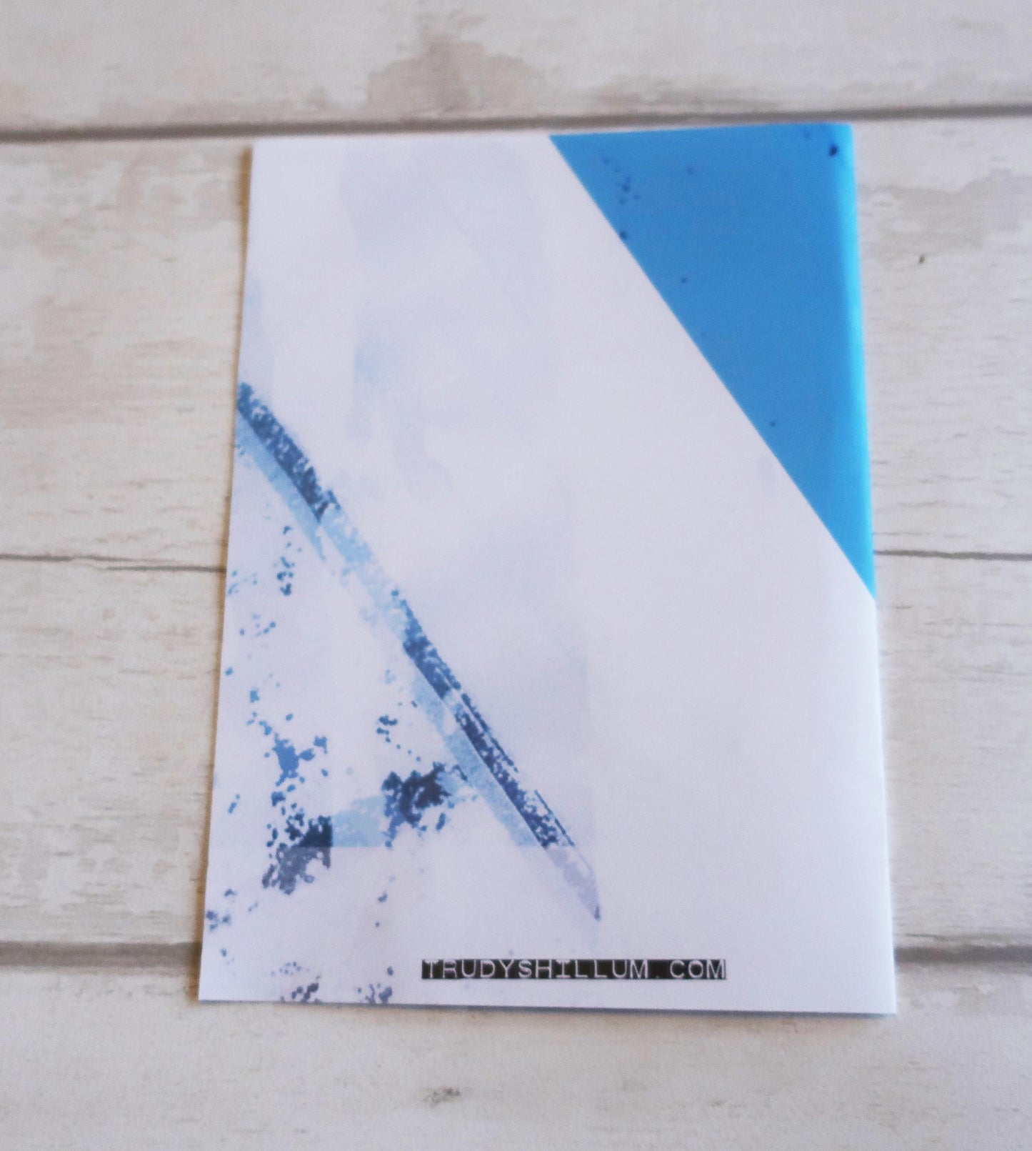 Card with blue abstract design on a wooden surface