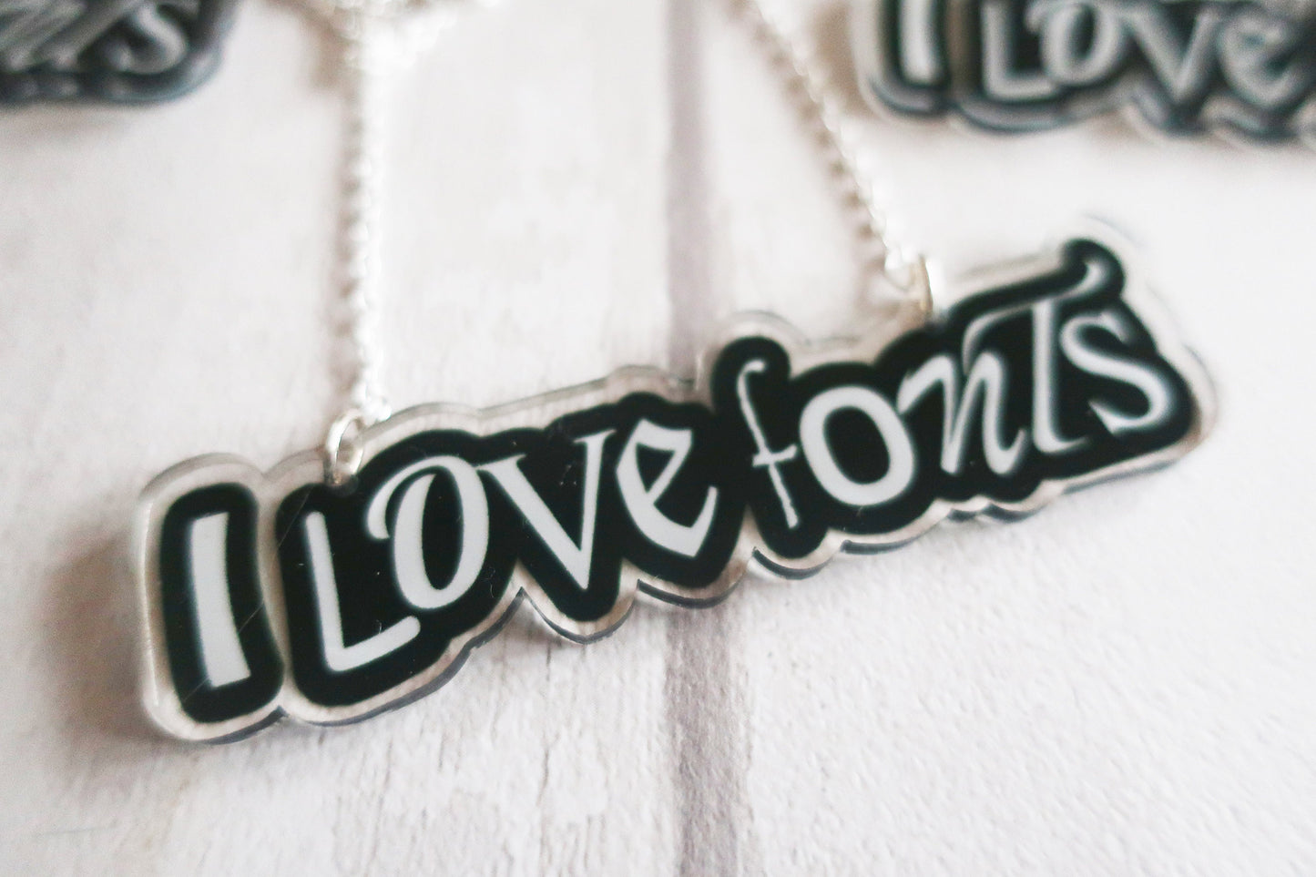 Necklace with 'I LOVE FONTS' pendant on a white background