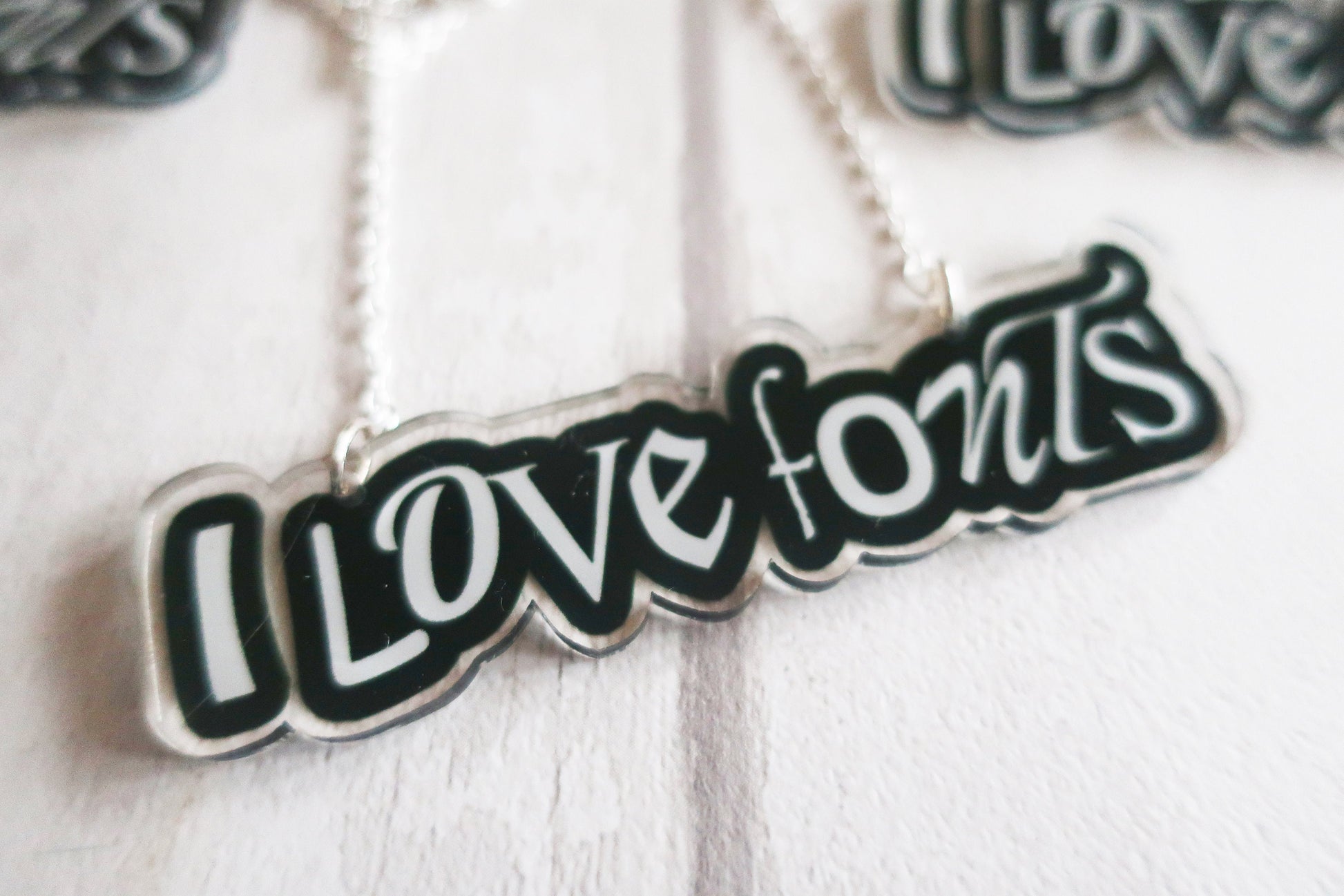 Necklace with 'I LOVE FONTS' pendant on a white background