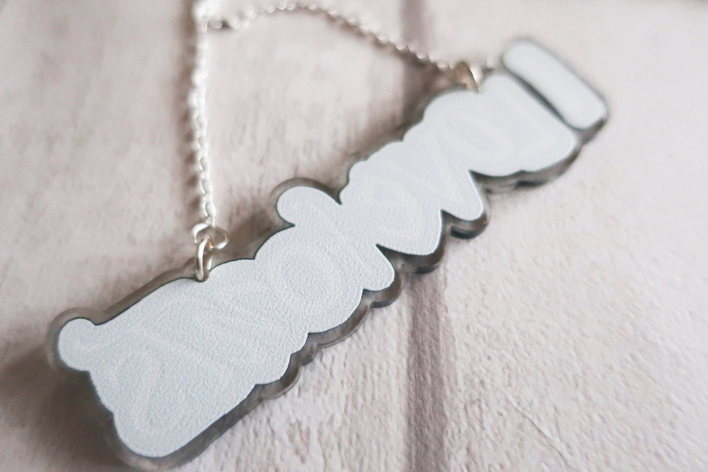 Silver pendant BACK on a light pink background