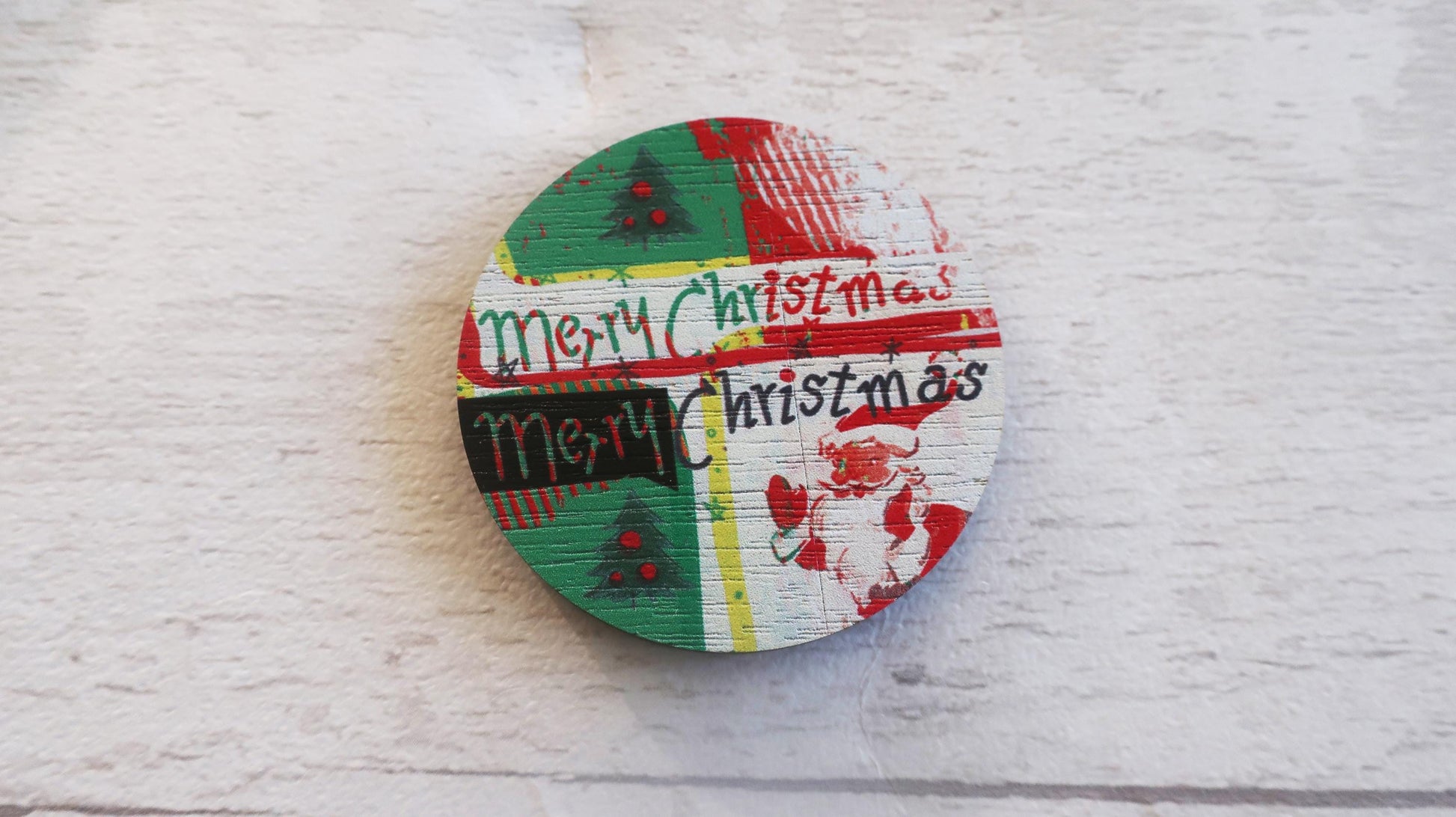 Round wooden badge with 'Merry Christmas' text on a white textured background
