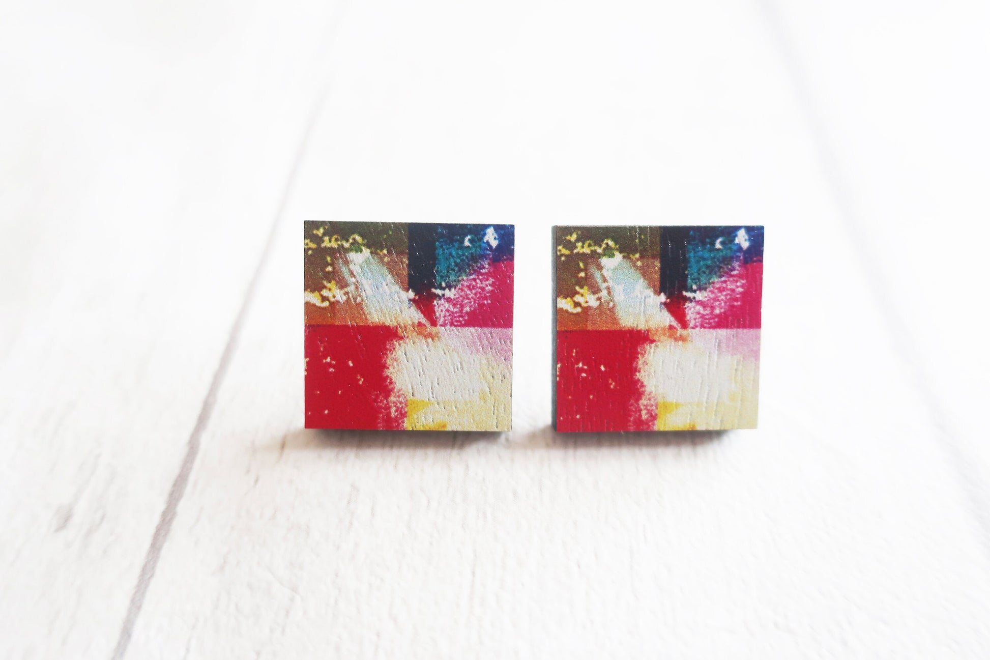 Colorful abstract square earrings on a white background