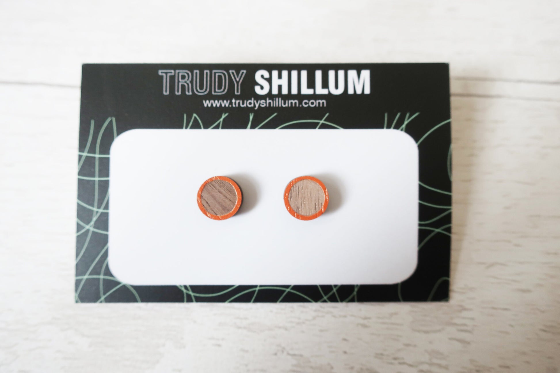 Wooden earrings on a Trudy Shillum branded card with a white background