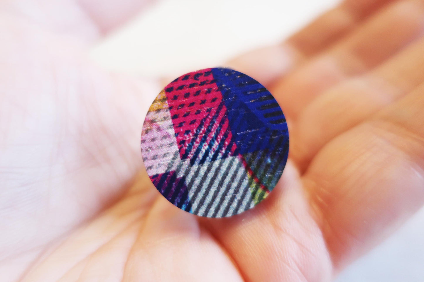 Colorful fabric ring held between fingers