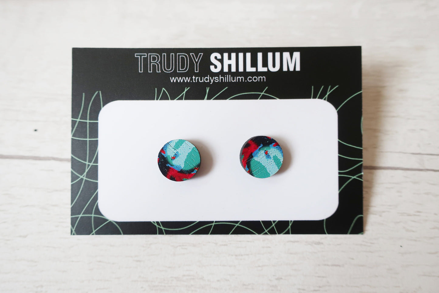 Pair of colorful round earrings on a Trudy Shillum branded card.
