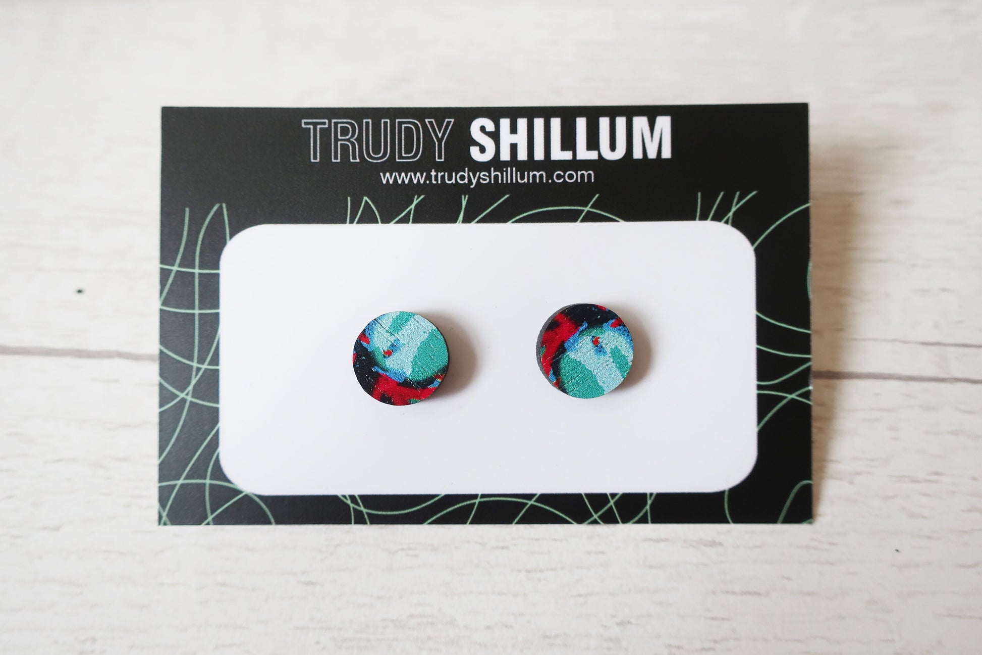 Pair of colorful round earrings on a Trudy Shillum branded card.