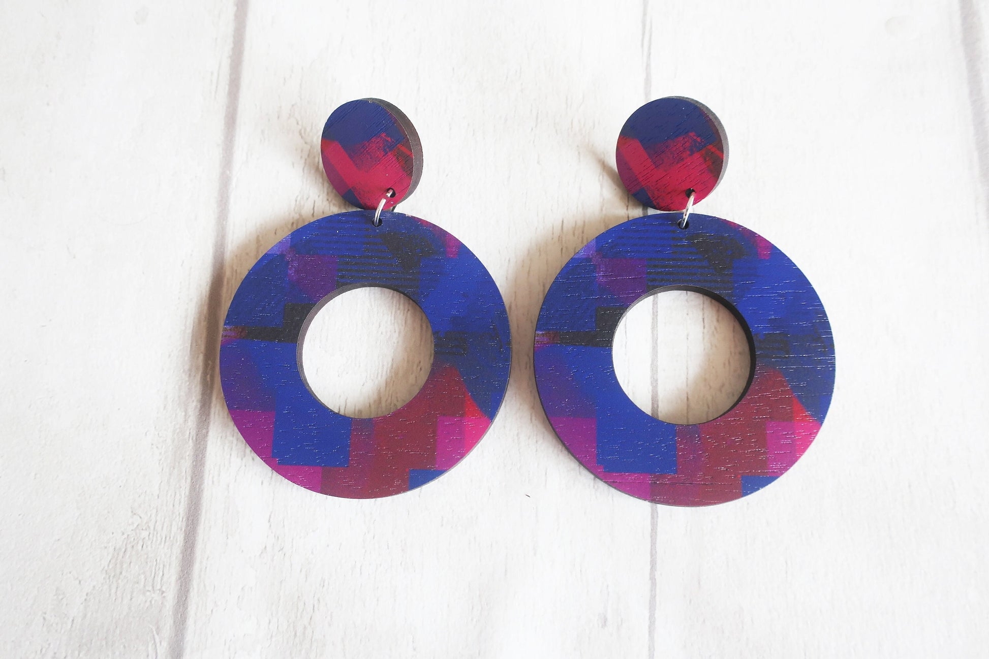 Pair of colorful circular earrings on a white background