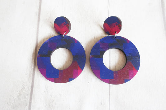 Pair of colorful circular earrings on a white background