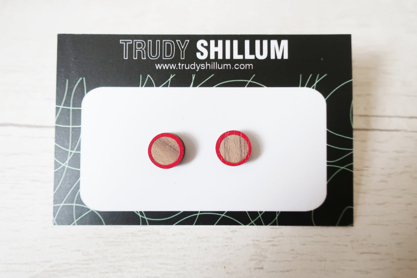 Wooden earrings on a Trudy Shillum branded card with a white background