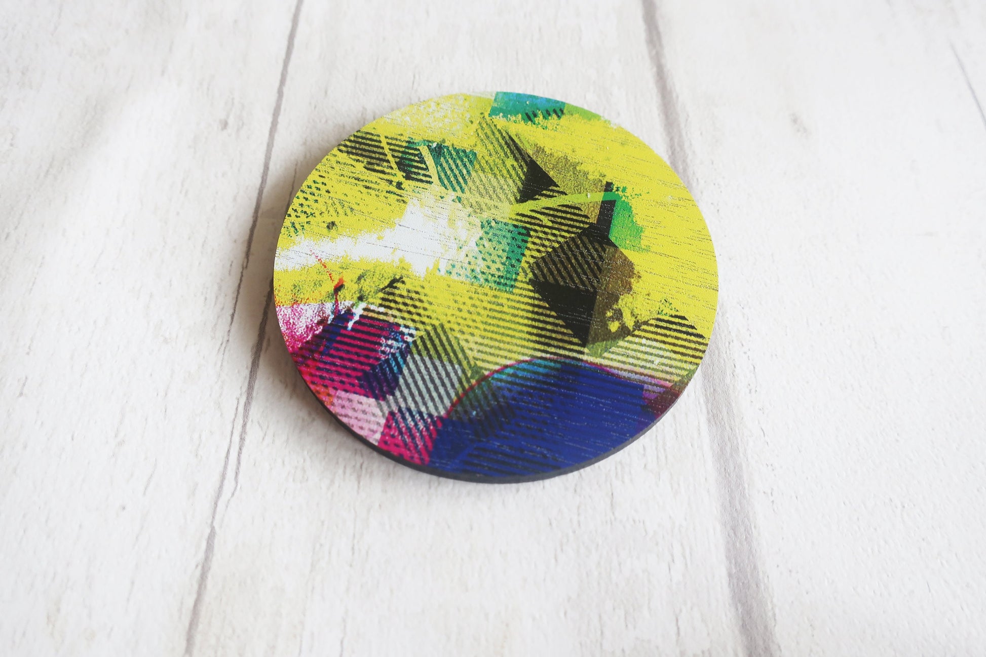 Colorful circular object with abstract design on a white surface