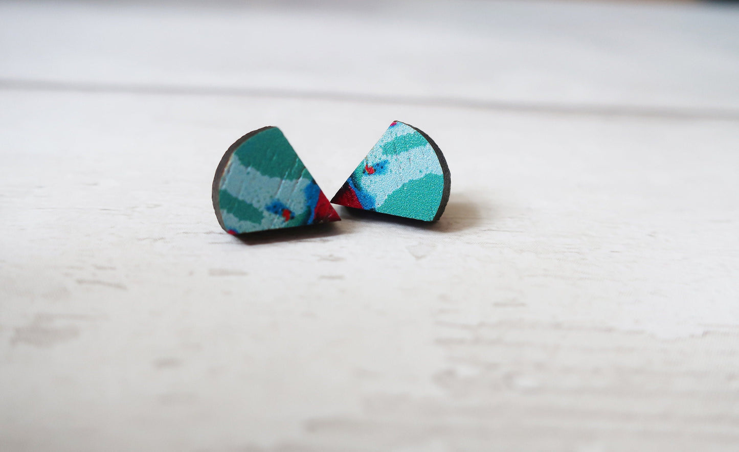 Pair of colorful earrings on a light wooden surface