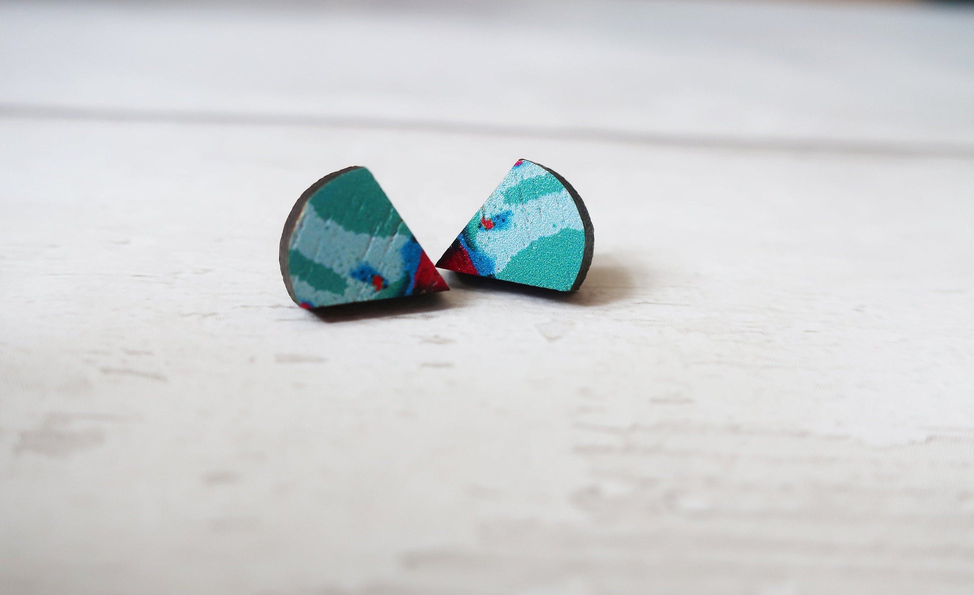 Pair of colorful earrings on a light wooden surface