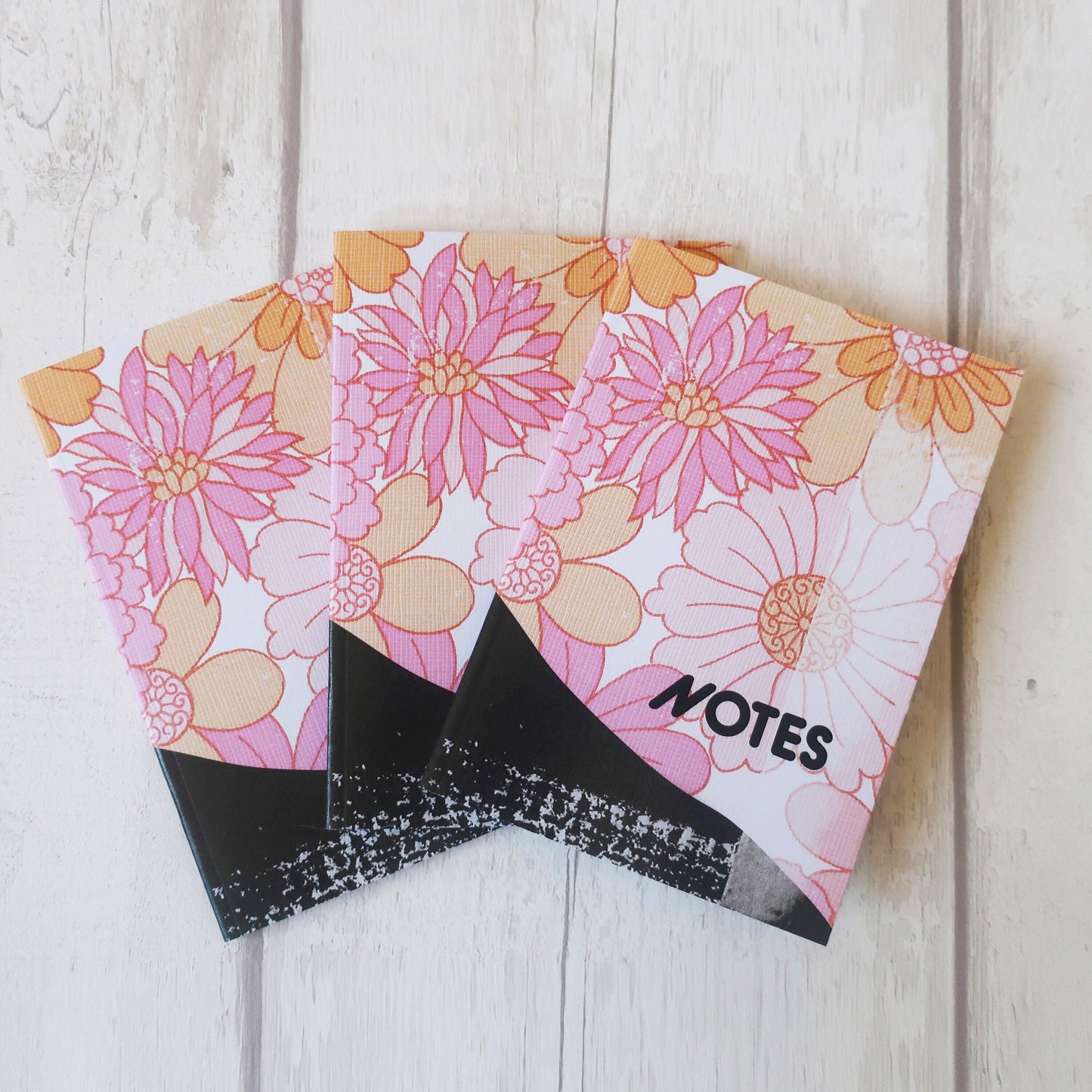Floral notebook with 'NOTES' label on a wooden surface