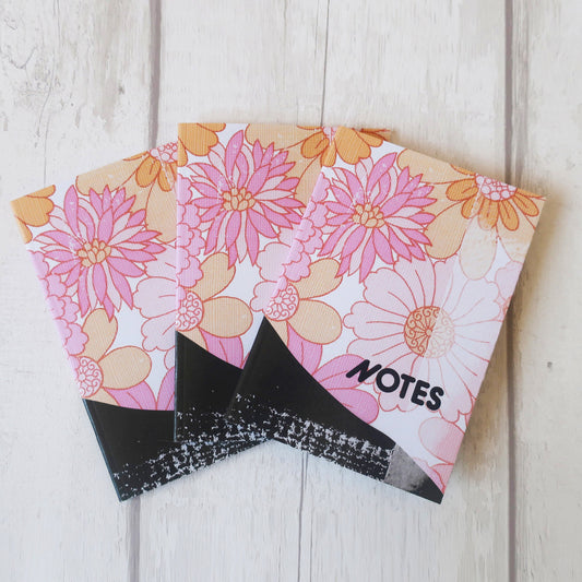 Floral notebook with 'NOTES' label on a wooden surface