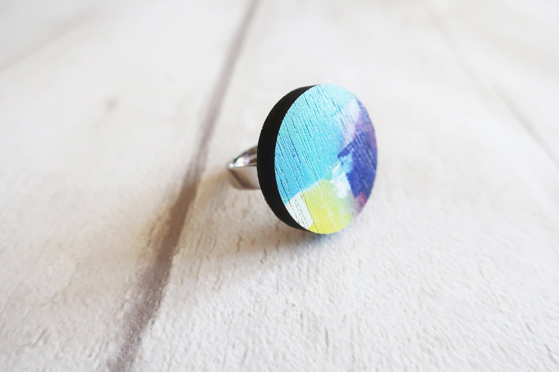 Colorful ring with a textured band on a white fabric background