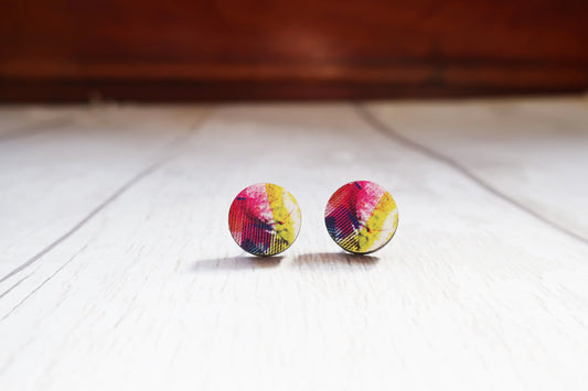 Colorful round earrings on a wooden surface