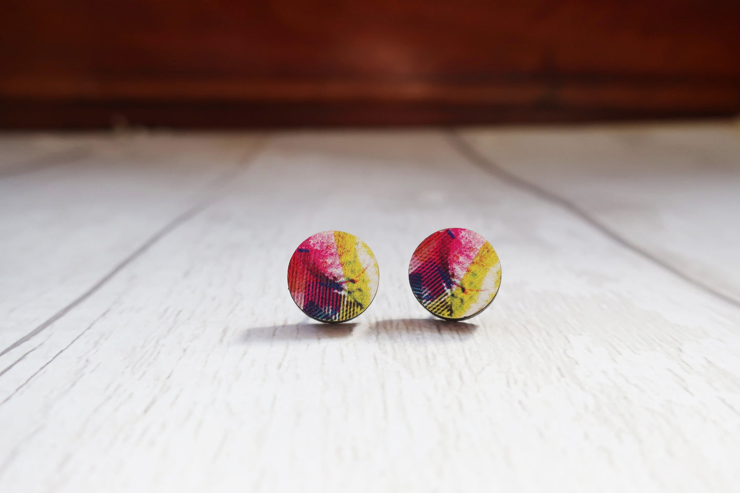 Colorful round earrings on a wooden surface