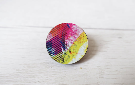 Round colorful pin brooch on a white surface