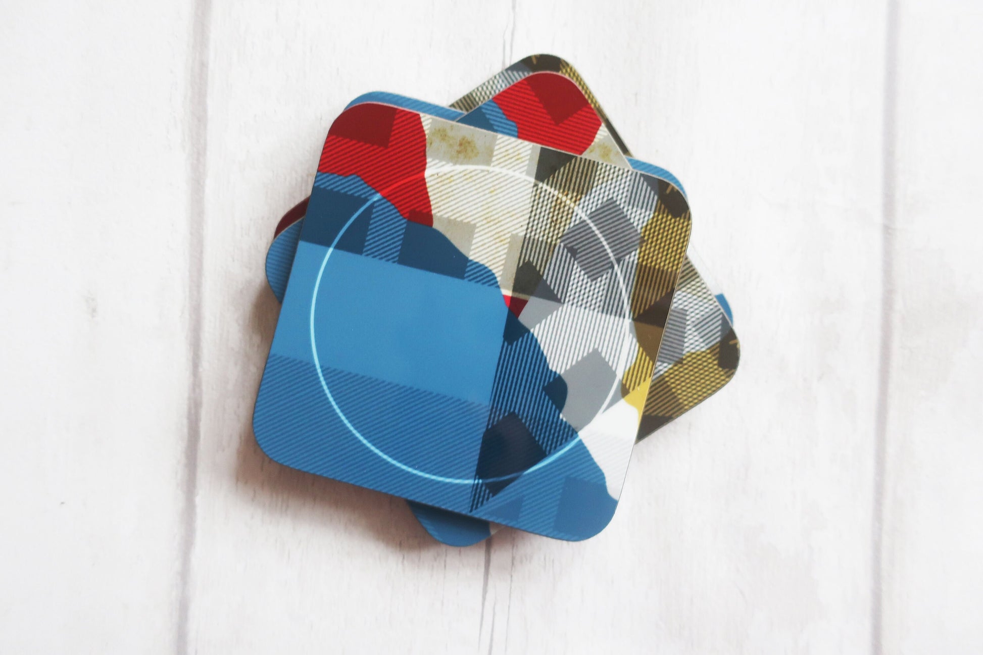 Set of colorful coasters on a white wooden surface