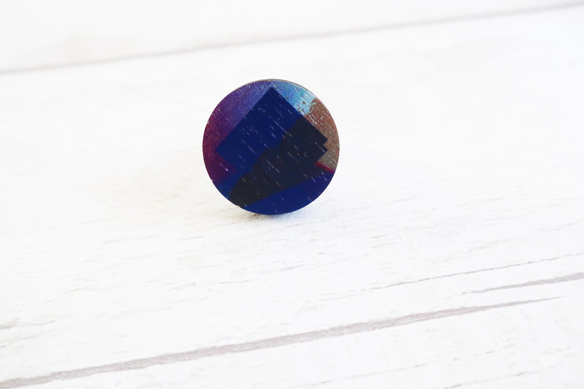 Round ring with multicolor pattern on a white wooden surface
