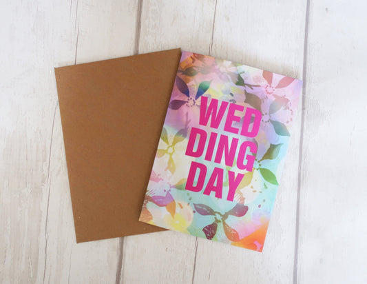 Colorful 'Wedding Day' card with a brown envelope on a light wooden surface