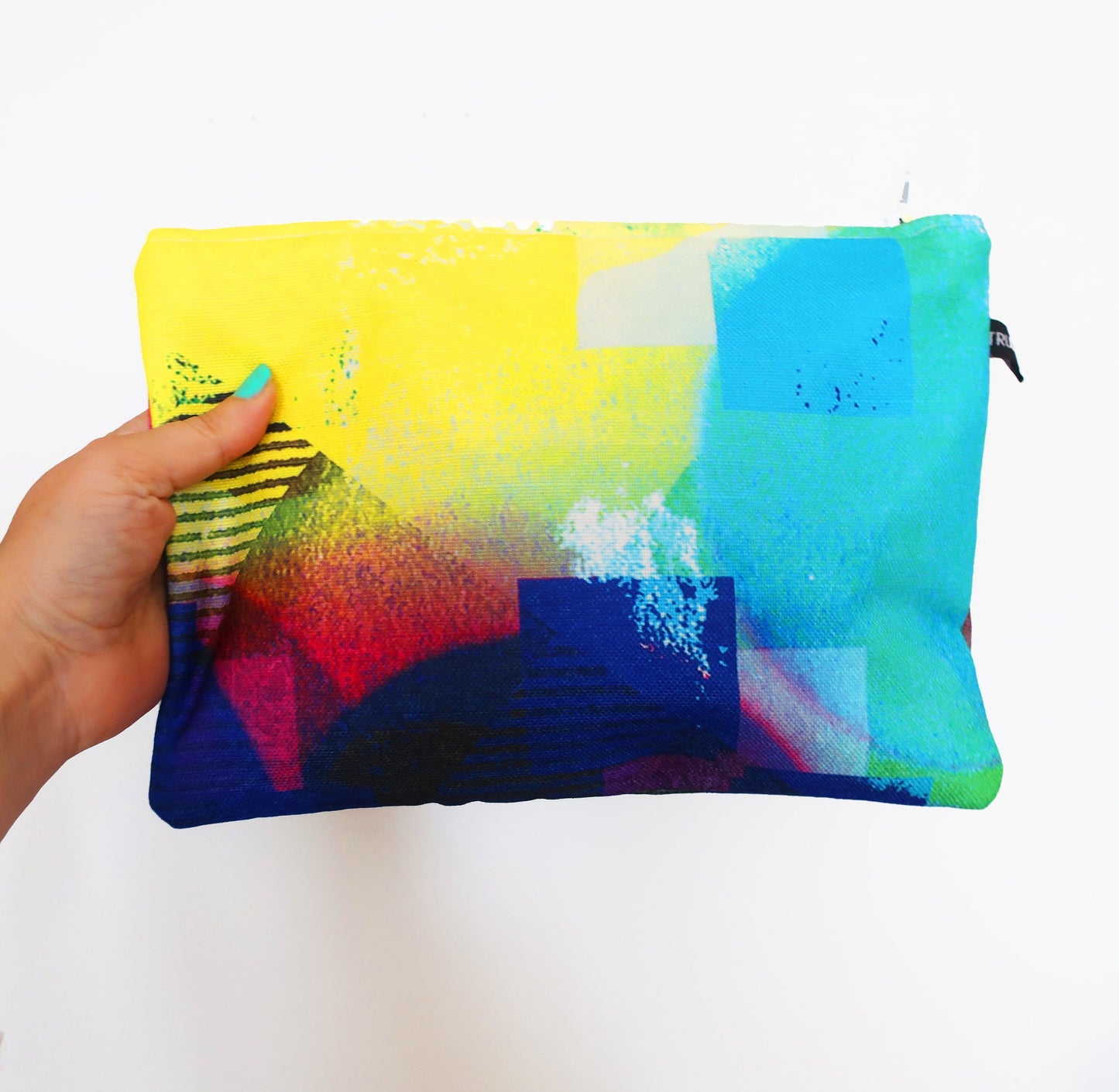 Colorful pouch held by a hand against a white background