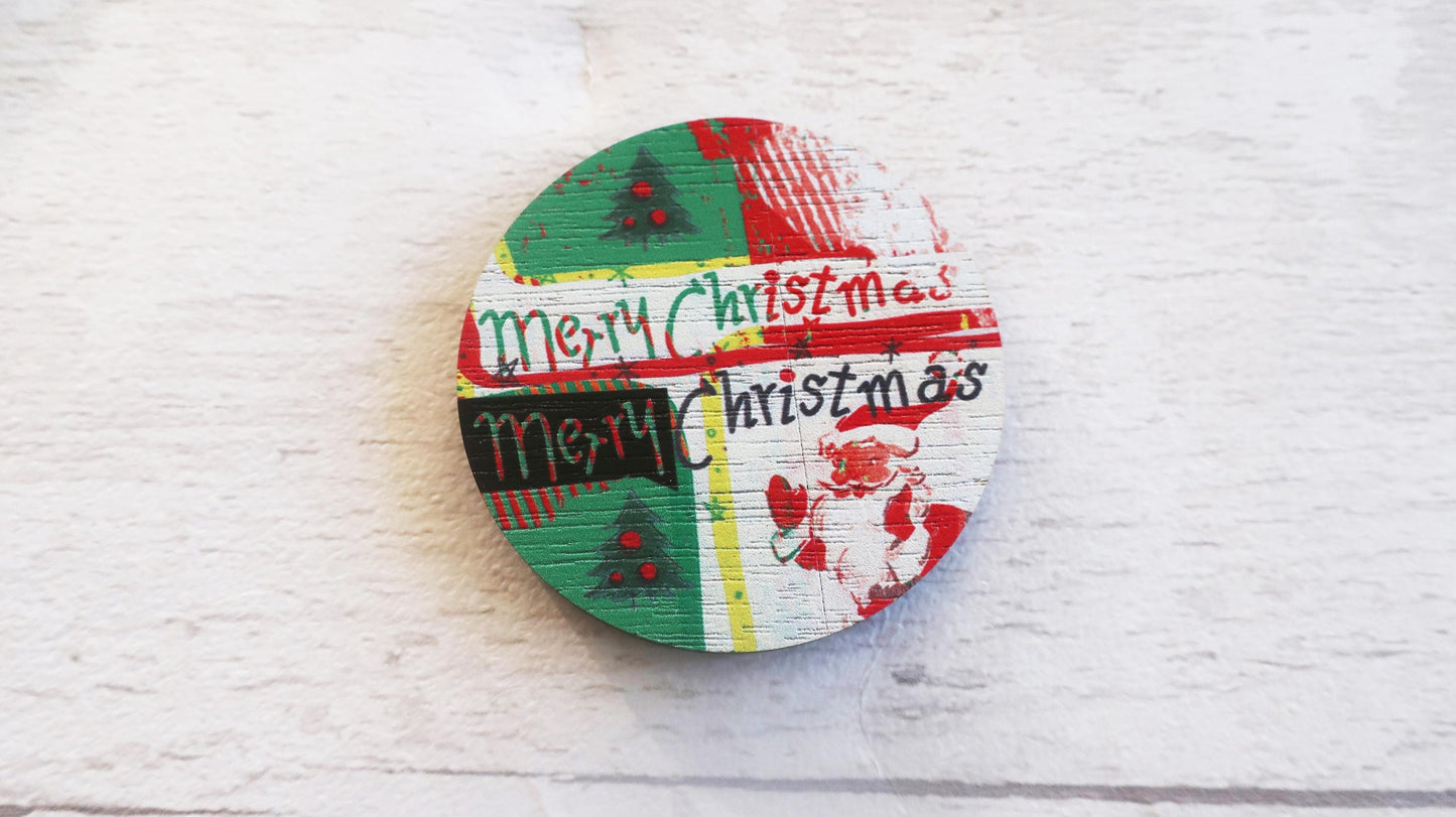 Round wooden badge with 'Merry Christmas' text on a white textured background