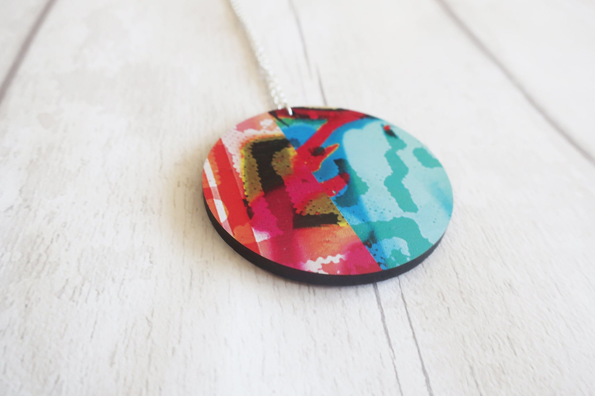 Colorful circular pendant on a white wooden surface