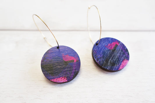 Pair of round earrings with a colorful pattern on a white background