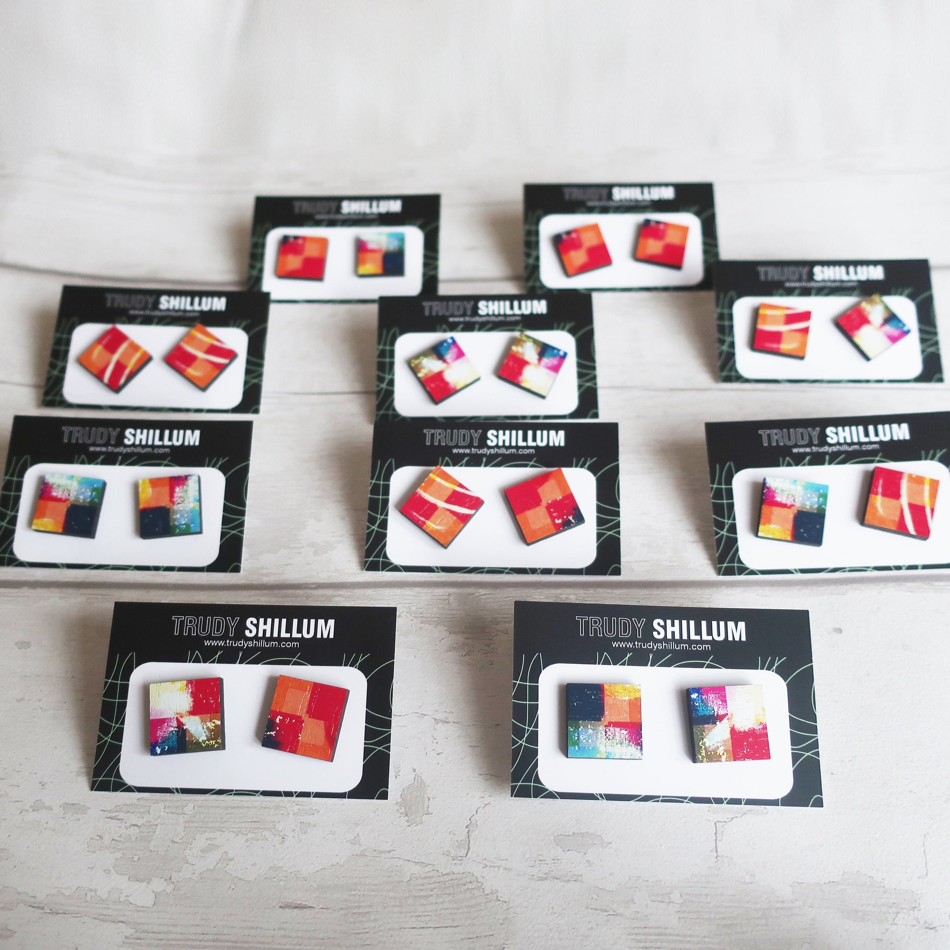 Multiple boxes of Trudy Shillum jewelry on a light wooden surface