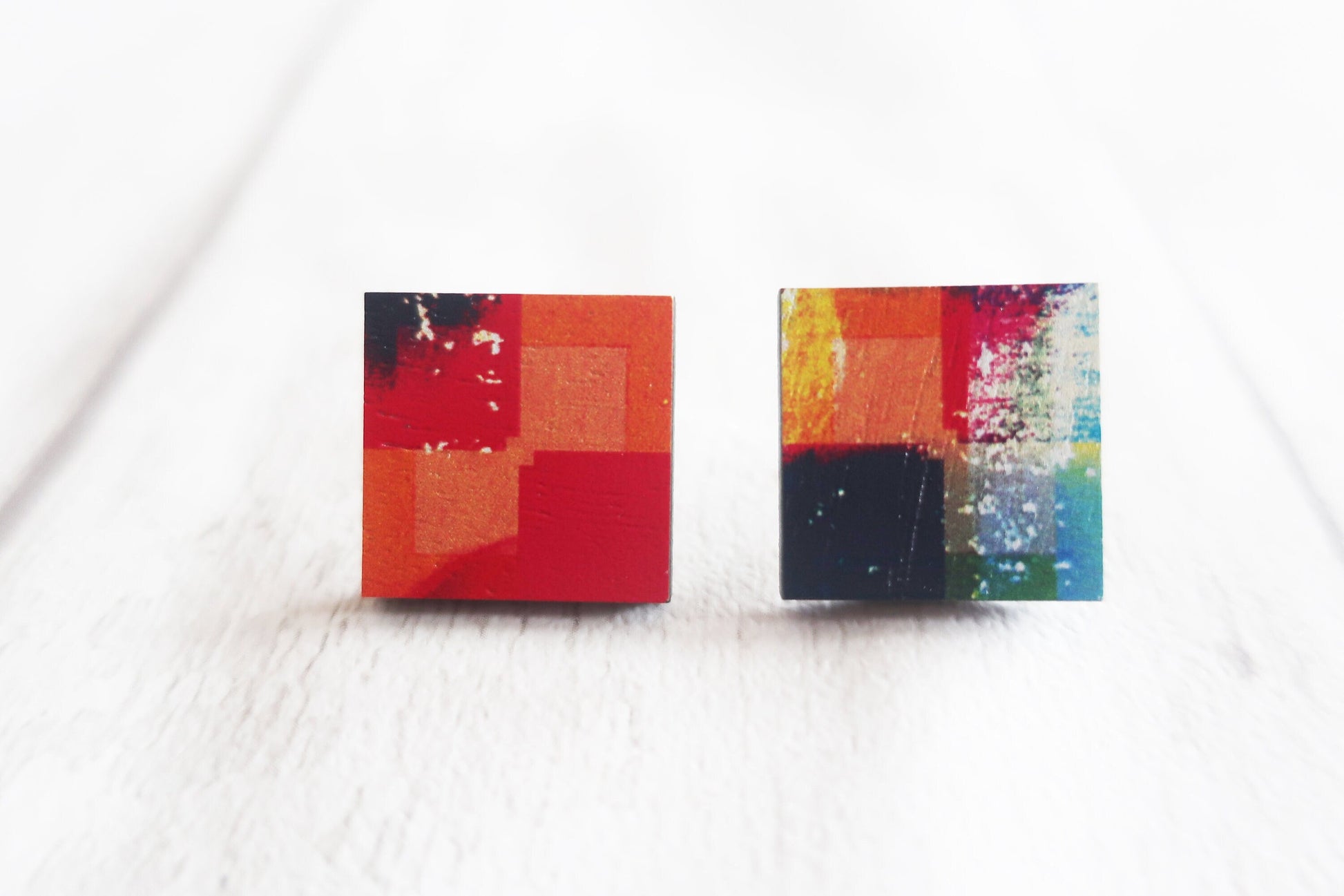Colorful square stud earrings on a white background