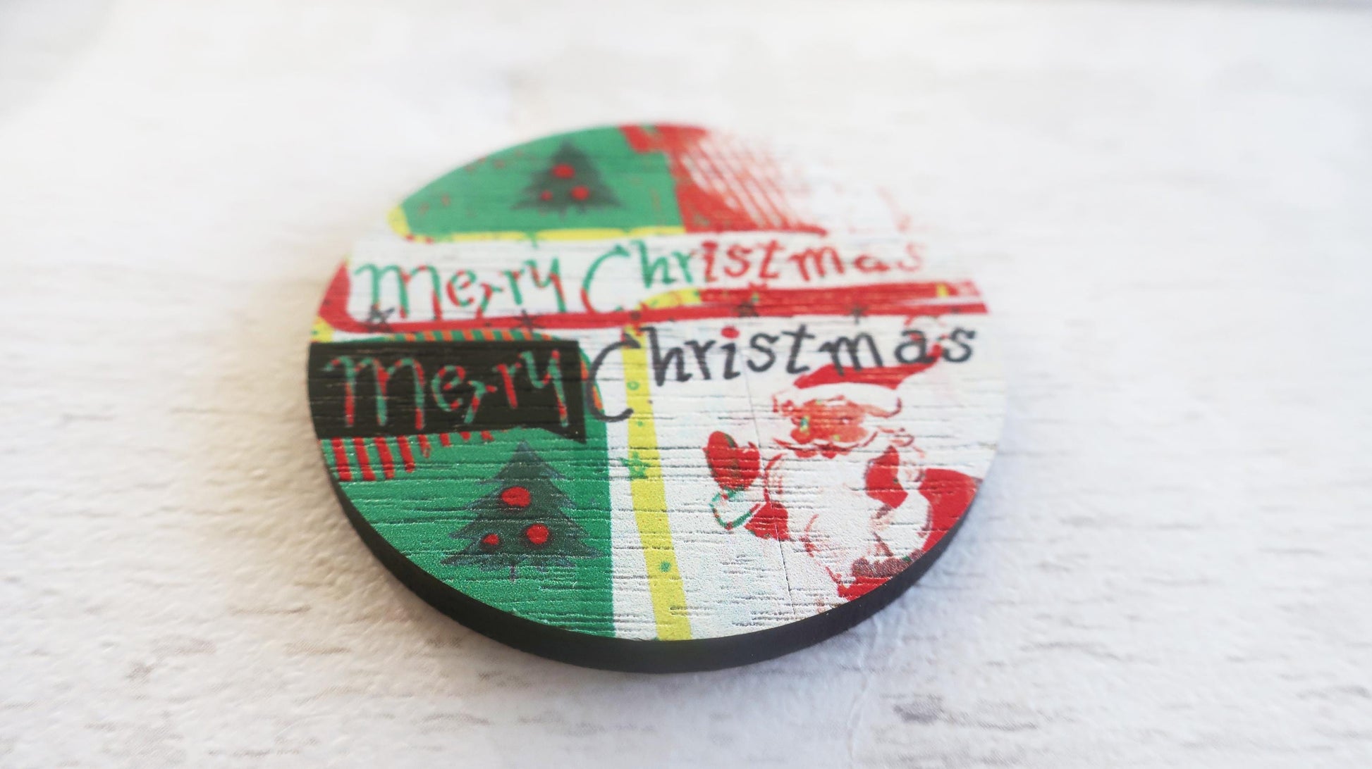 Round wooden badge with 'Merry Christmas' text and festive designs on a white background