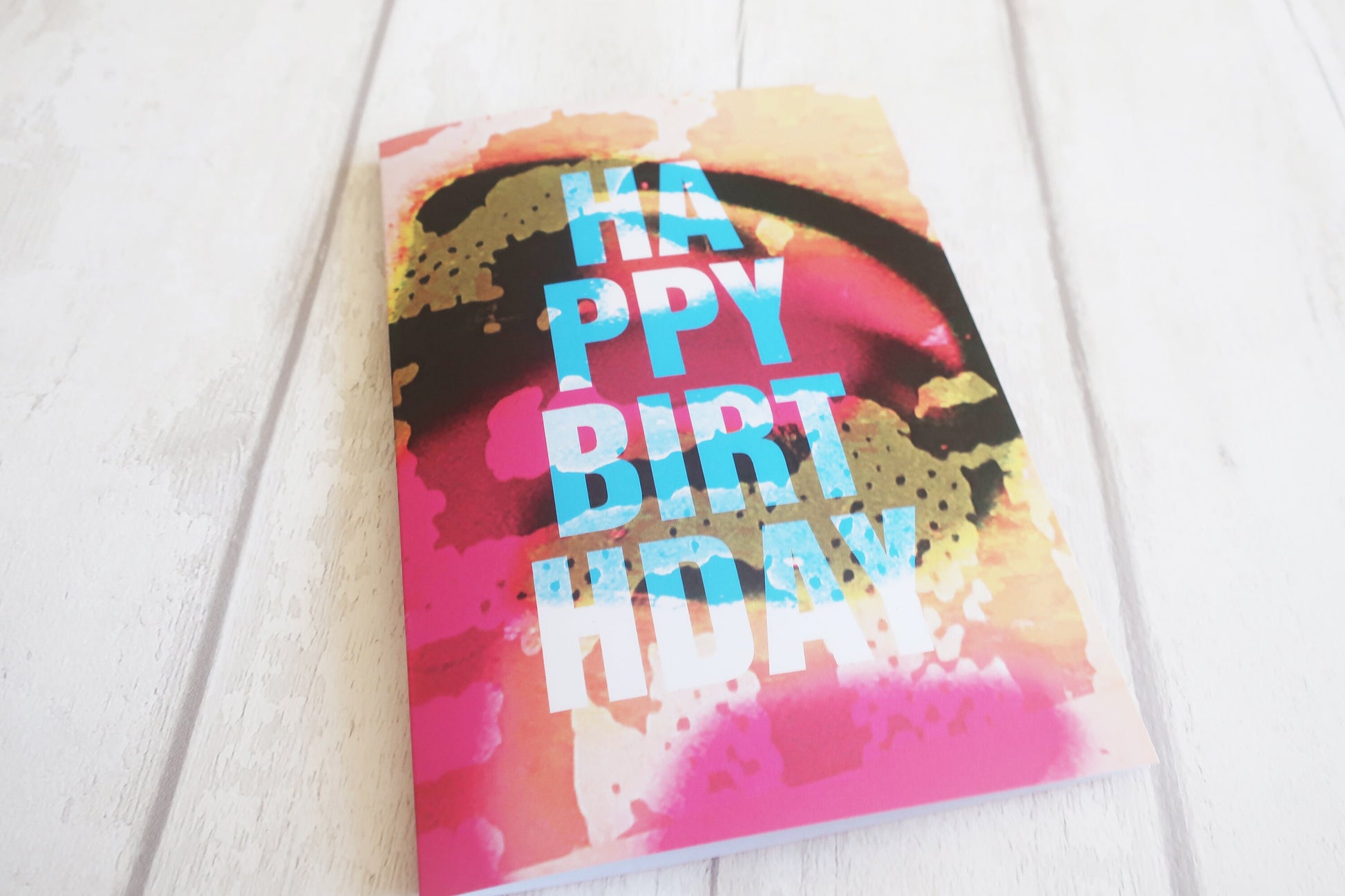 Colorful birthday card with 'Happy Birthday' text on a white surface