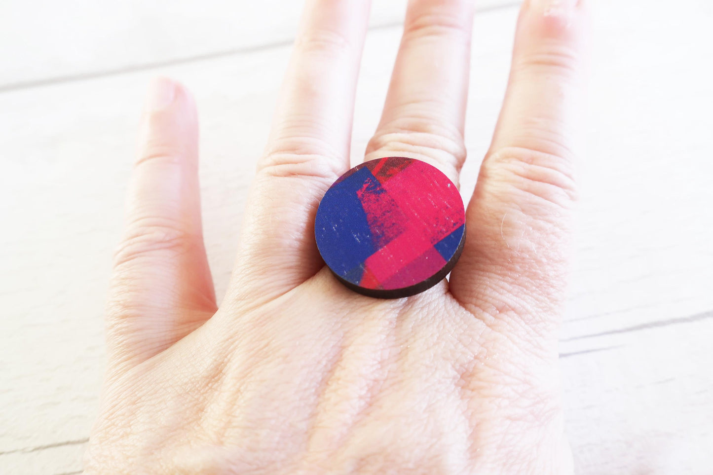 Hand holding a colorful ring with a white background