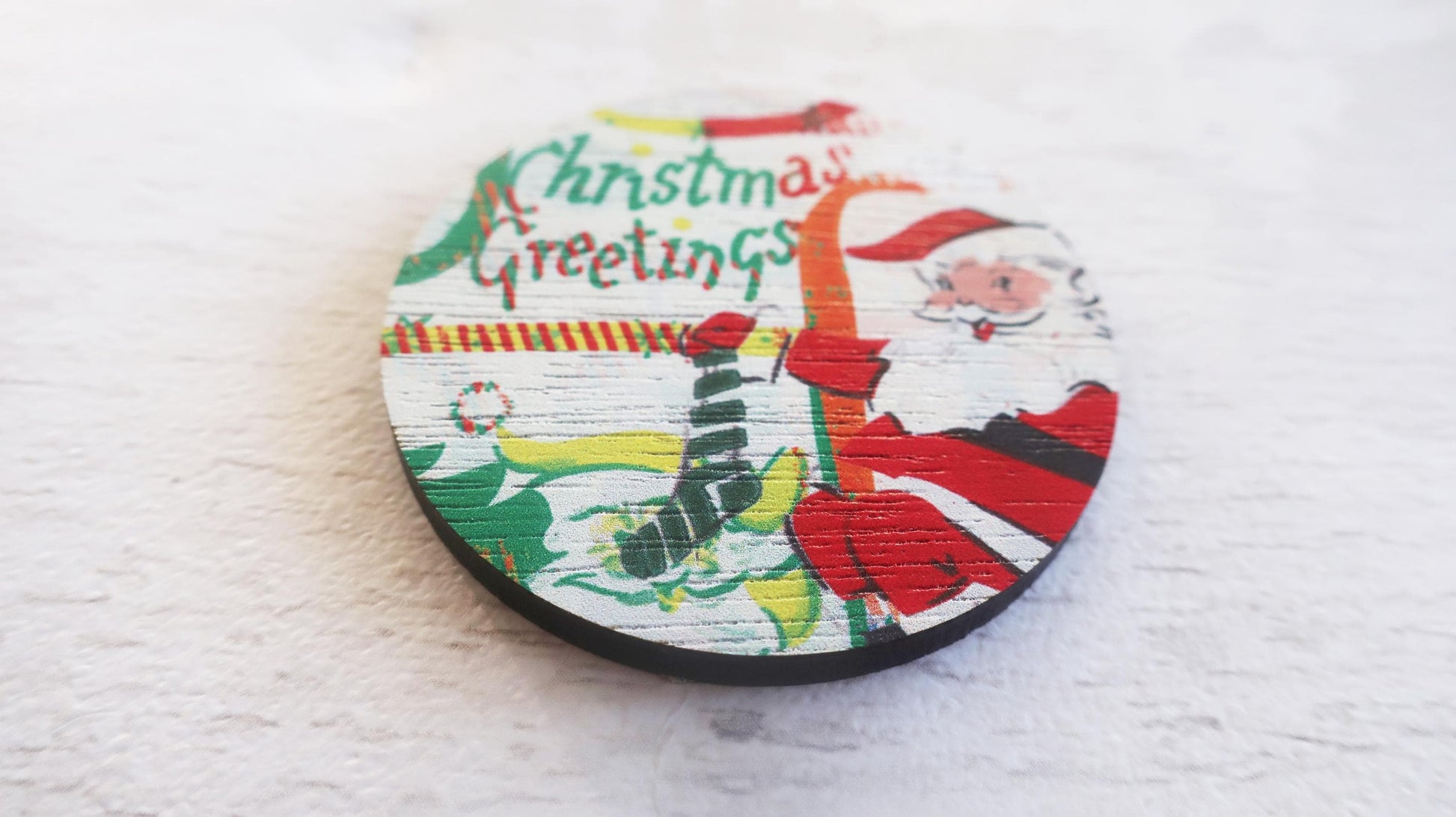 Round Christmas-themed badge with Santa Claus design on a white background