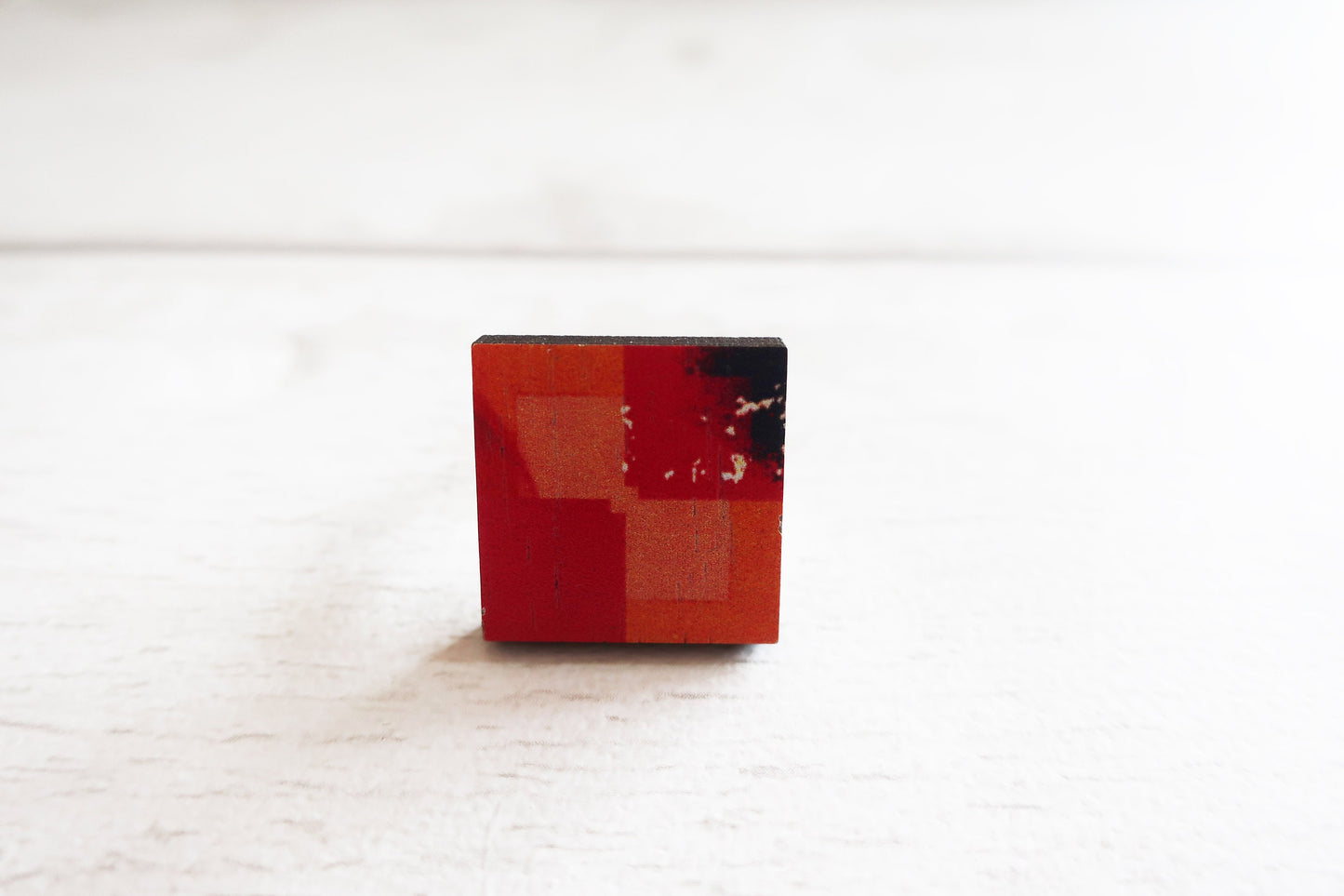 Small red and black ring  on a white surface