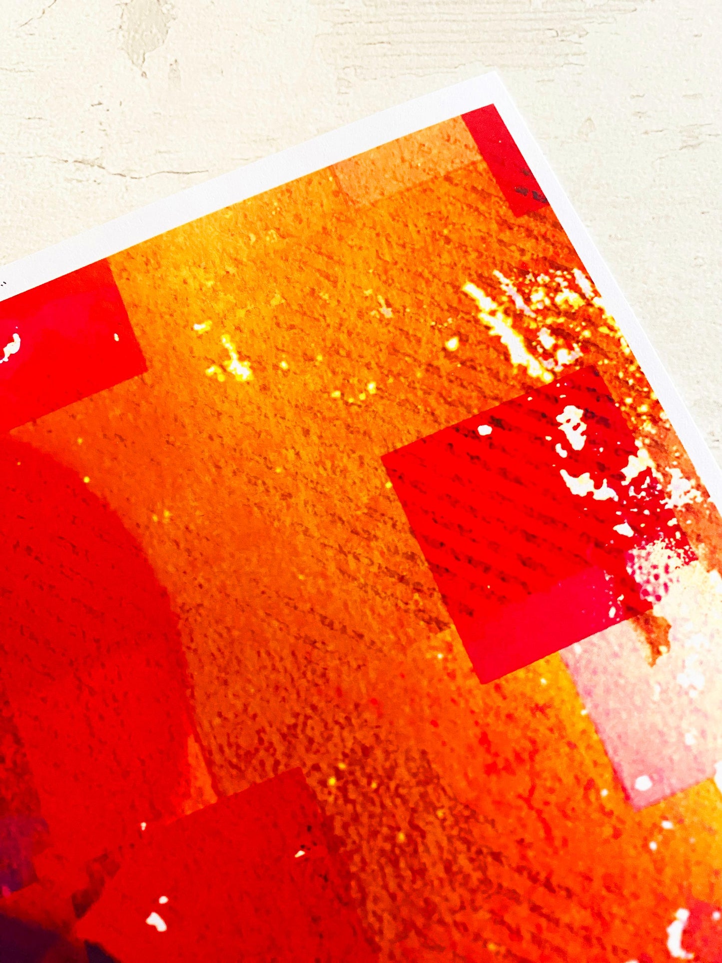 Abstract art with red and orange colors on a textured surface