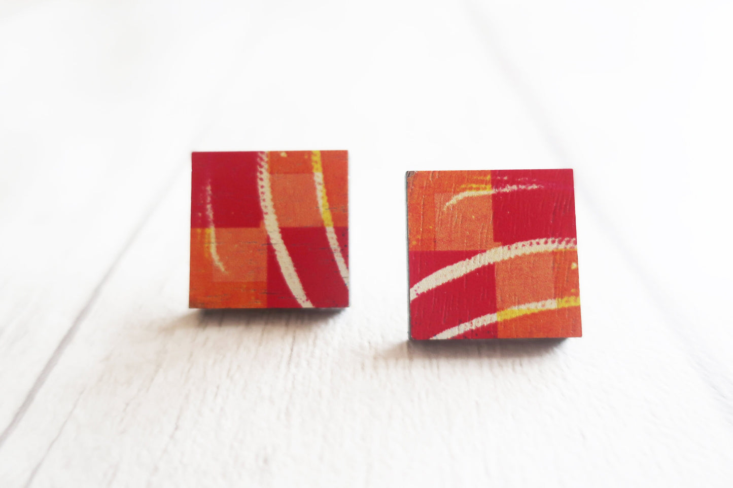 Square earrings with red and orange design on a white background