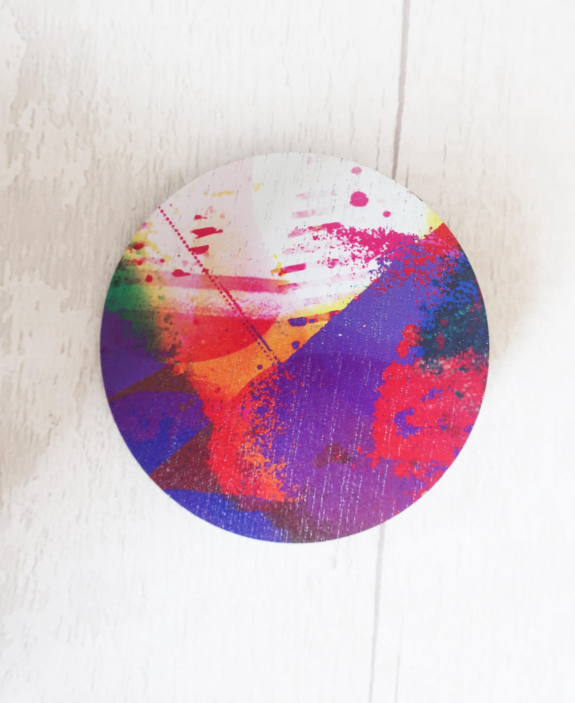 Colorful abstract circular brooch on a white background