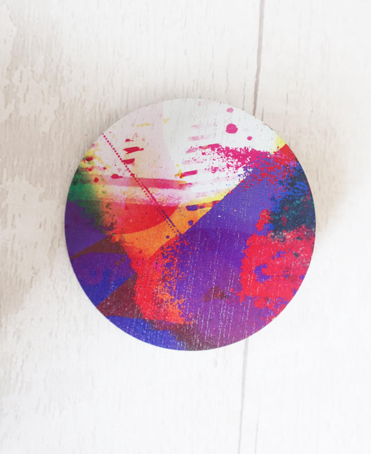 Colorful abstract circular brooch on a white background
