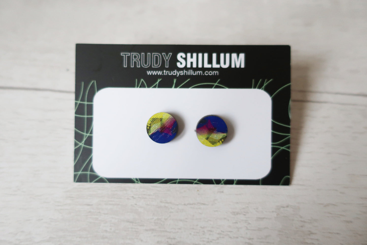 Colorful round earrings on a Trudy Shillum branded card.