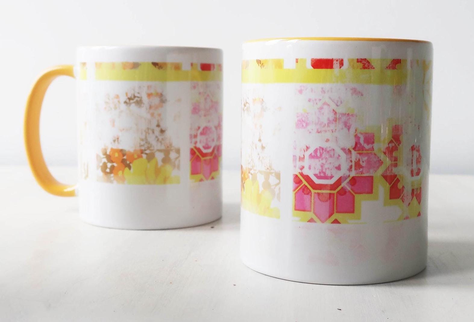 Two mugs with colorful geometric patterns on a white background