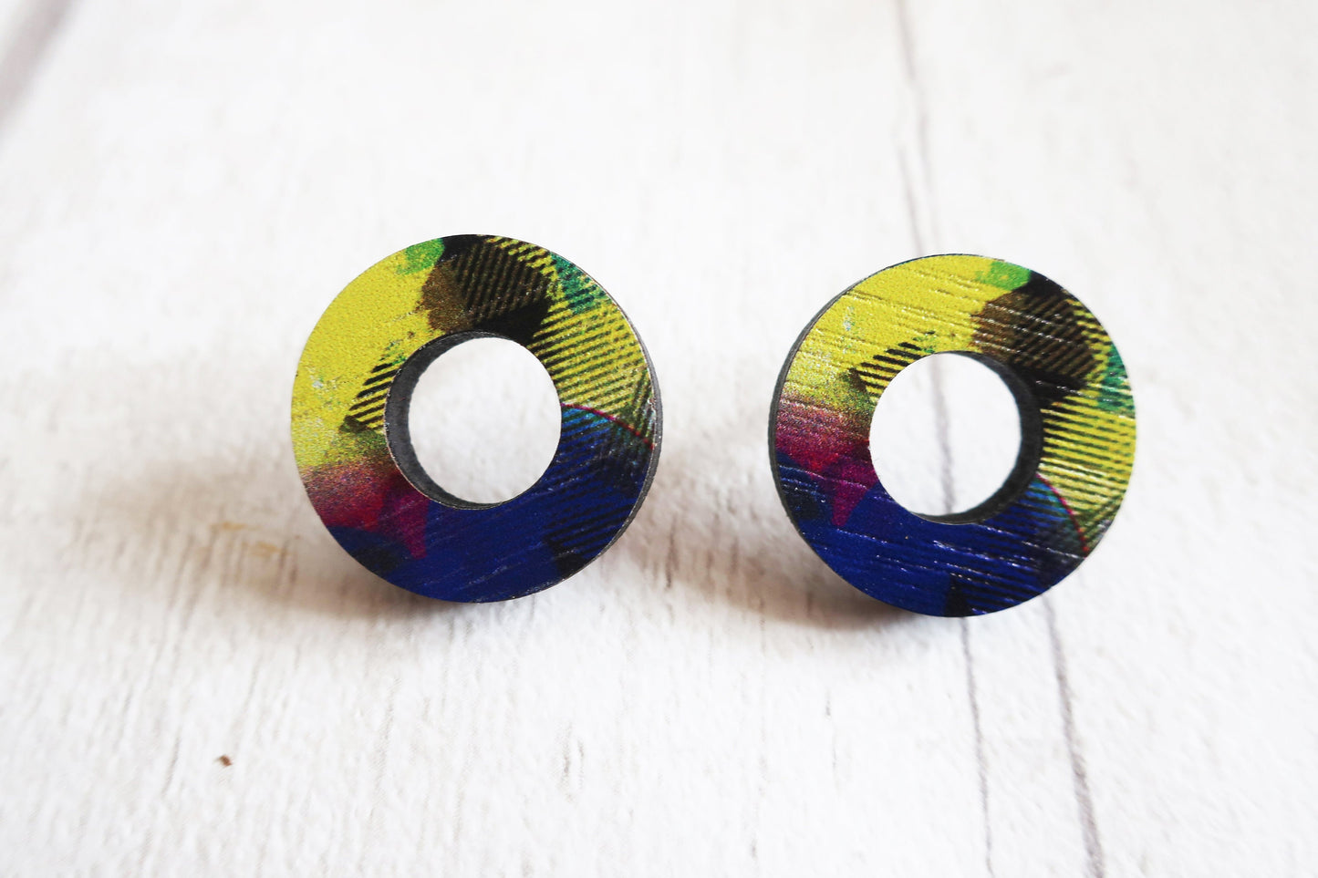 Pair of round earrings with colorful patterns on a white background