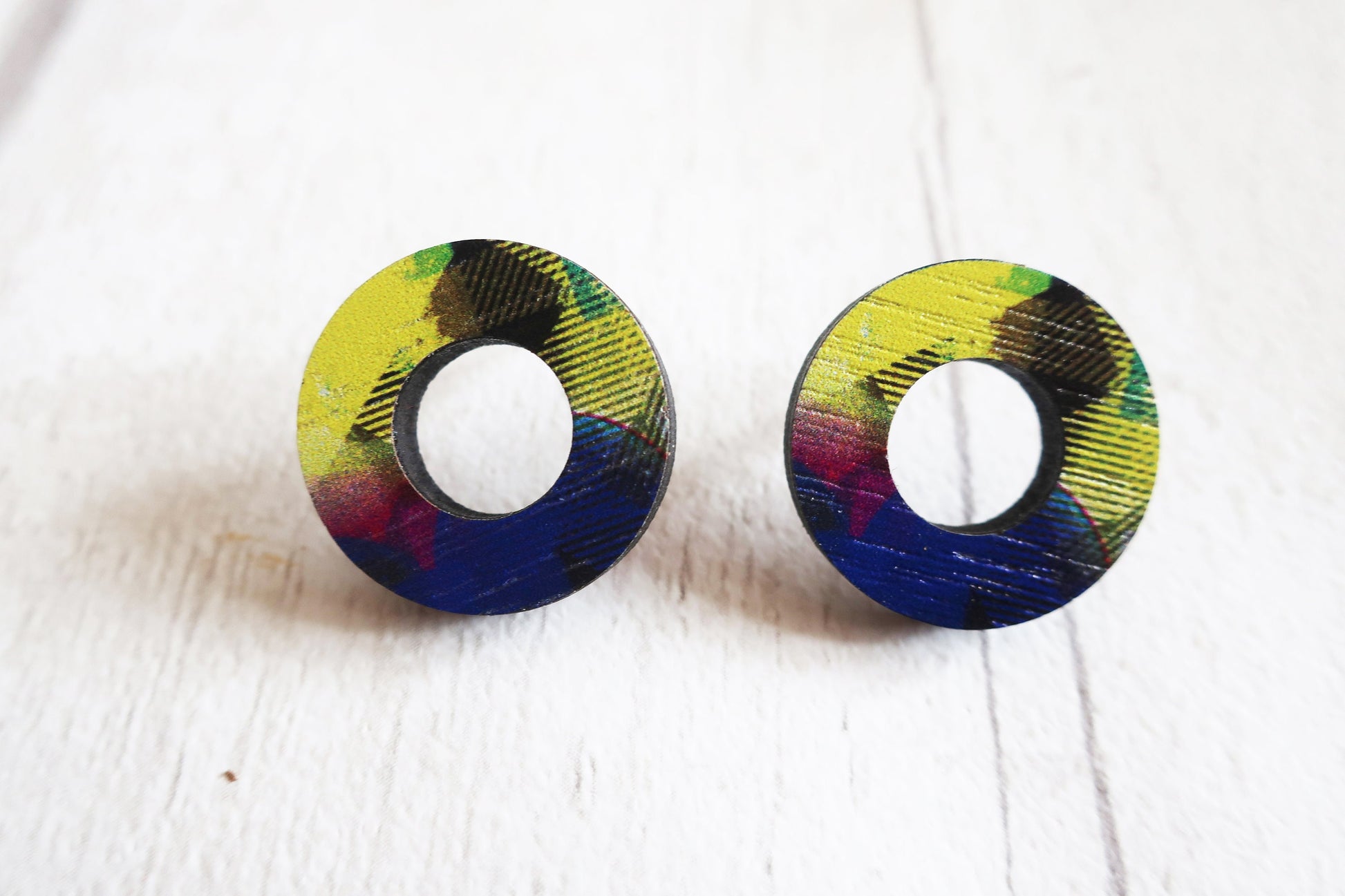 Pair of round earrings with colorful patterns on a white background